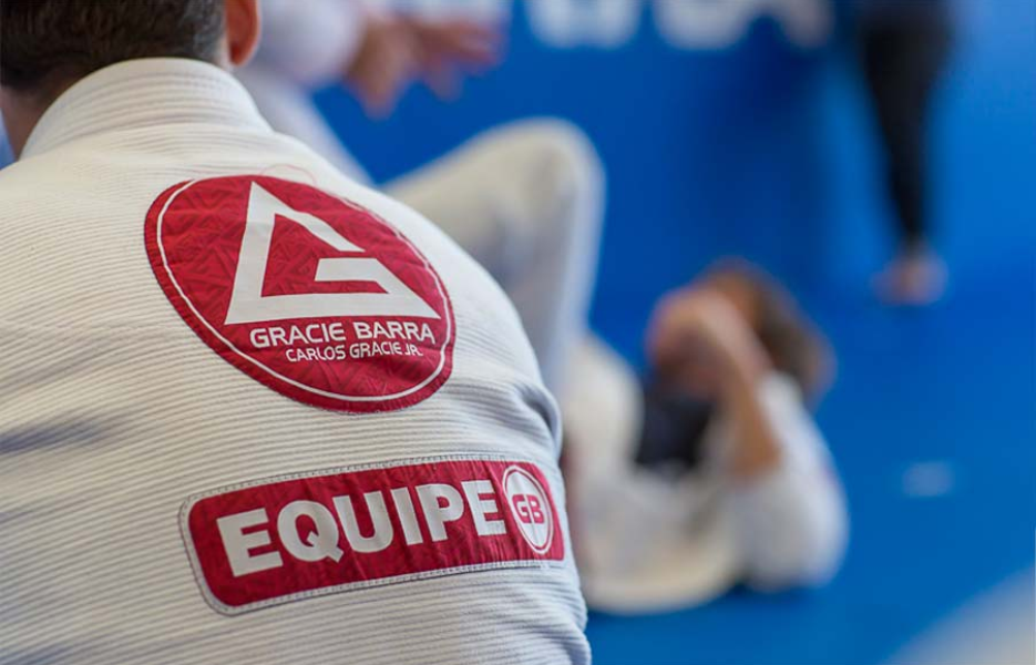 Foto das costas de um homem sentado usando o quimono da Gracie Barra